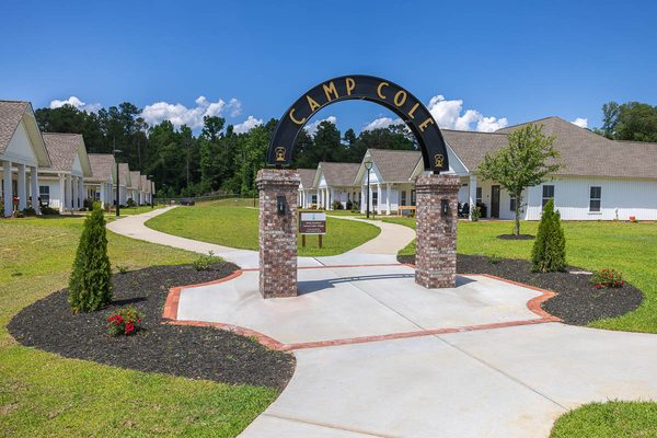 The Camp Cole entrance arch with cabins behind it