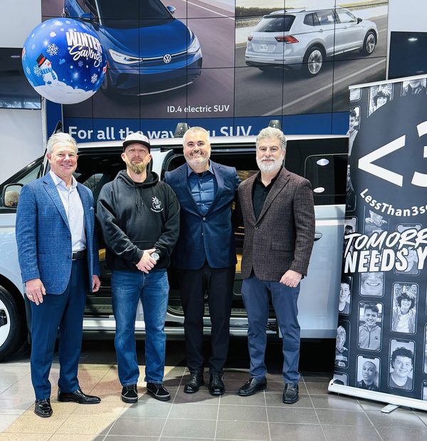 From left: Sims Floyd (SCADA), Rep. Brandon Guffey, Mark Mason Jr. and Samer Abraham standing in front of the Volkswagen ID. Buzz next to a Less Than 3 banner