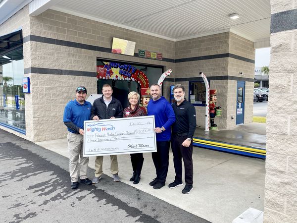 Group holding an $11,000 Mighty Wash check for Prisma Health Children's Hospital outside the car wash