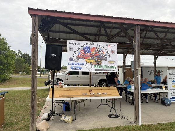 Covered pavilion with the 46th Annual Mustang & Ford Show banner, dated 10-03-26, in Elgin, SC