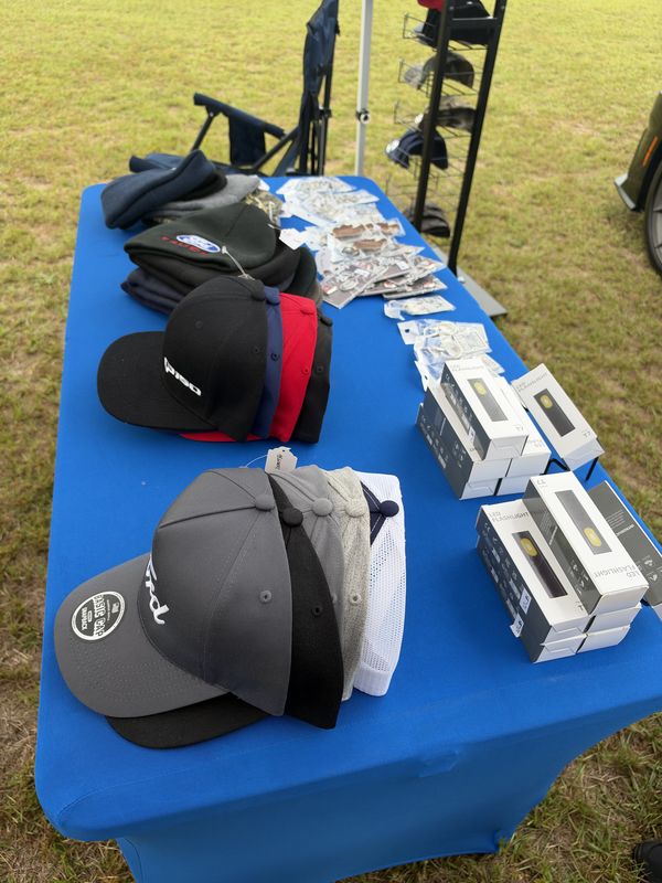 Ford caps and gift boxes on a blue table at the 46th Annual Mustang & Ford Show in Elgin, SC